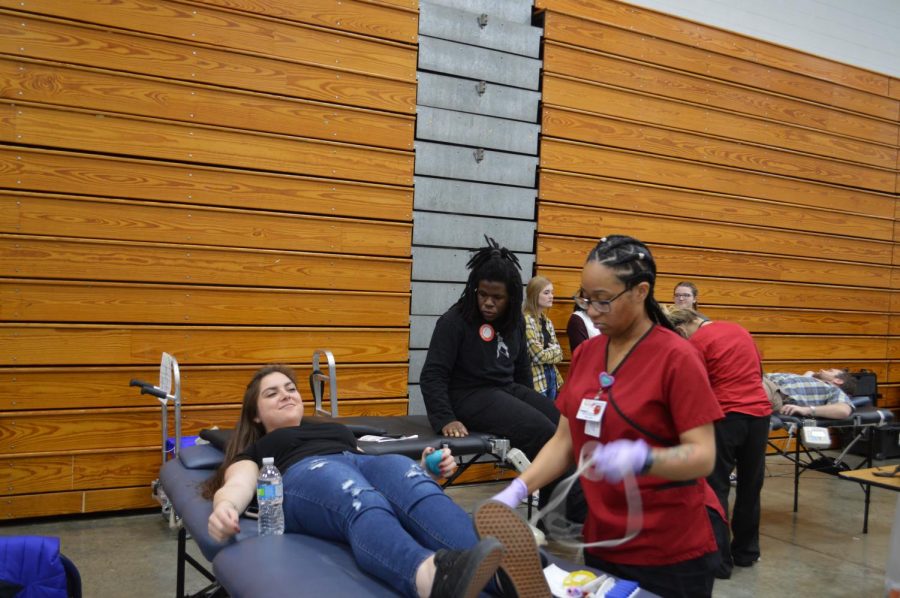 Senior Olivia Martin tries sitting up after she finished giving blood.
