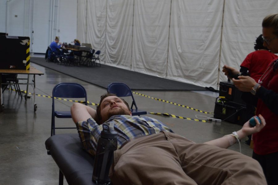 Sophomore biology teacher, Jared Eaton lays down as he donates blood and talks to students.