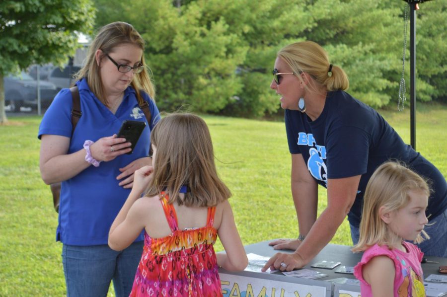 Lincoln Trail Elementarys Youth Services Center Coordinator Jennifer Williams speaks with a student and parent at the Bruin Fest on July 22 at Central Hardin High School.