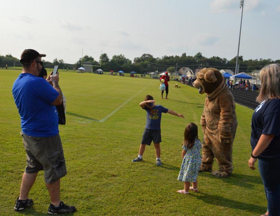 Lakewood Elementary first grader Mason Peters dabs with the Bruin Bear at the Bruin Fest on July 22 at Central Hardin High School as dad  Eric Peters captures the moment and sister Maggie, three years old, looks on.