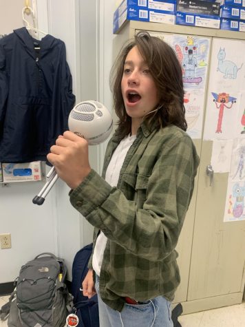 Freshman Mason Durham singing into a microphone.