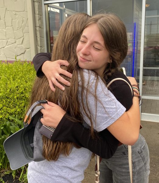 College freshmen Mara Green (right) and Caroline Mann (left) embracing before they go off to school.