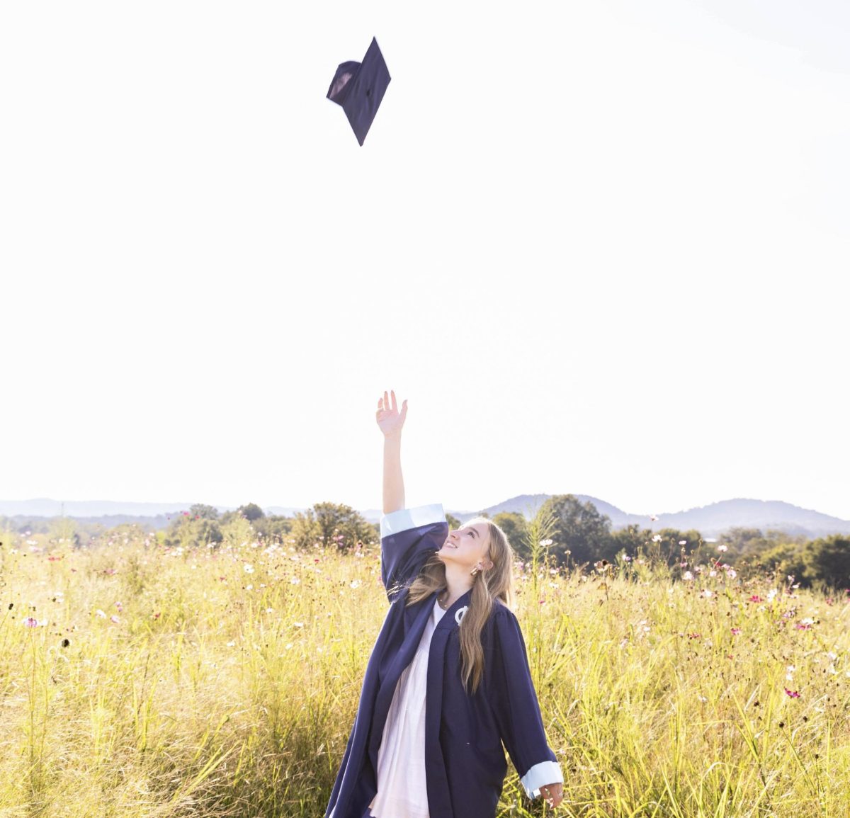 Senior Syra Lundergan mimics the graduate tradition of tossing the cap on Sept. 2 during her senior pictures session.