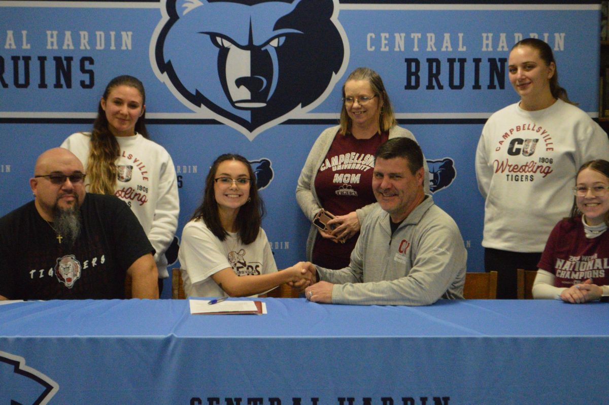 Lily Tingle shakes hands with Campbellsville Universitys wrestling coach after signing with the program on Feb. 20. Tingle is the manager for the wrestling team here at Central and involved in our own Central Hardin Band.
