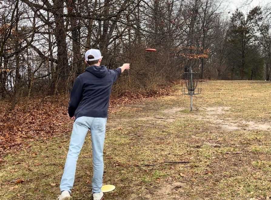 Senior Jeffery McMahan advancing on the Freeman Lake disc golf course. This is a standard disc golf basket that is considered a hole. Photo courtesy of Jeffery McMahan.