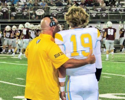 New head coach Phillip Stockdale talks new quarterback Caleb Irwin through the next play at Henderson County on Sept. 6. Former QB Zackery Spurrier moved on to pursue a baseball career at UK.