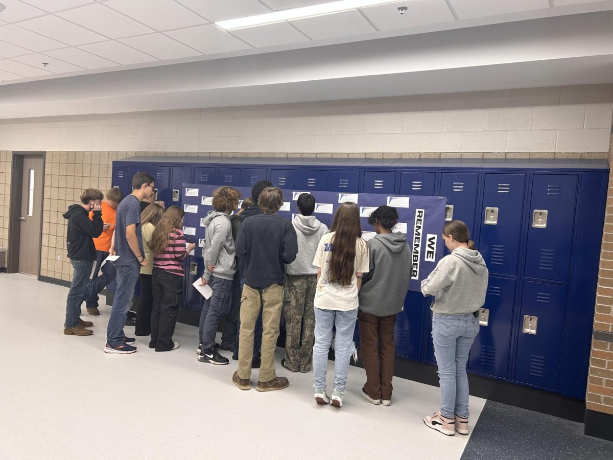 Junior English teacher Susan Sherrard's 5th block class reading librarian Sarah Bauer's display of staff members' 9/11 stories. (Sept. 10)