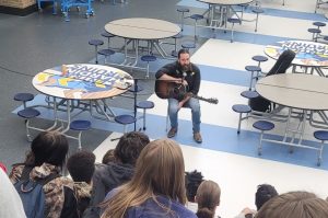 Students from junior English and guitar classes listen to Nashville singer-songwriter Dave Kennedy share tips for writing as well as experiences in the music industry on Oct. 21. Junior English students have been working on developing their voice and style as a writer. 