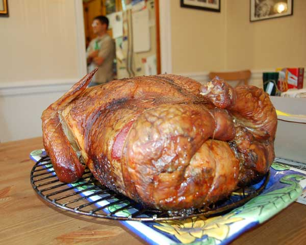 A Turducken sits on a dinner table, ready to feed a family. It is a traditional meal that consists of a duck and chicken stuffed into a turkey.