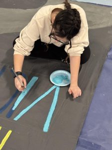 Senior Evelyn Barner uses her years of experience in Visual Art to paint a banner for the upcoming spirit week (Jan. 31).