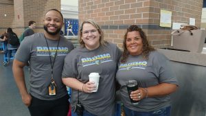 Boys' basketball coach Tavon Johnson, assistant principal Emily Wortham, and teacher Amy Pritt sport their '25-26 faculty shirt while on morning duty Aug. 8. Teachers were awarded their first spirit day of the year after sophomore Tate Loving sank a free throw in the first-day assembly on Aug. 7.