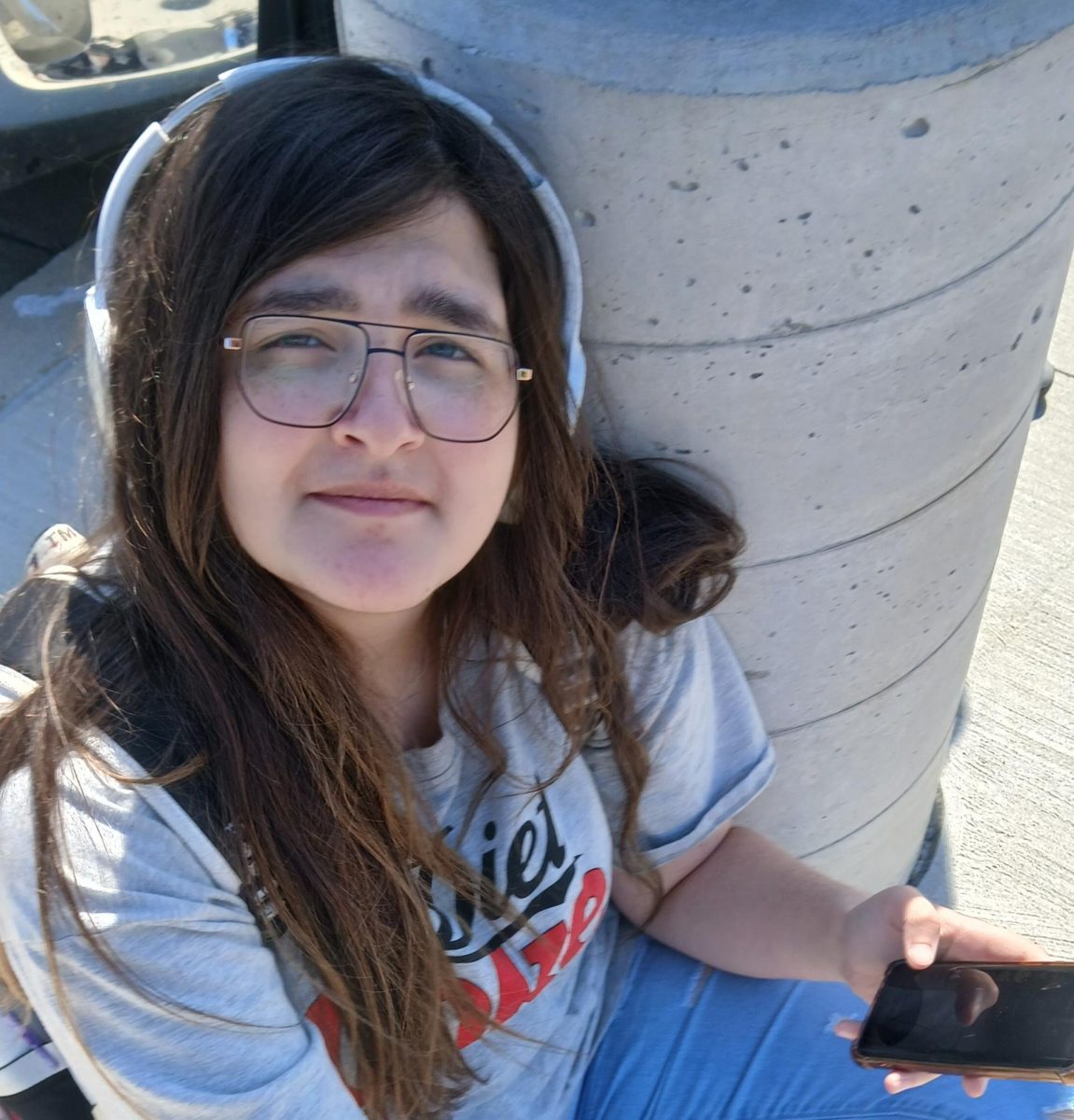 Layla Adele-ramen listening to music while she waits for the bus.