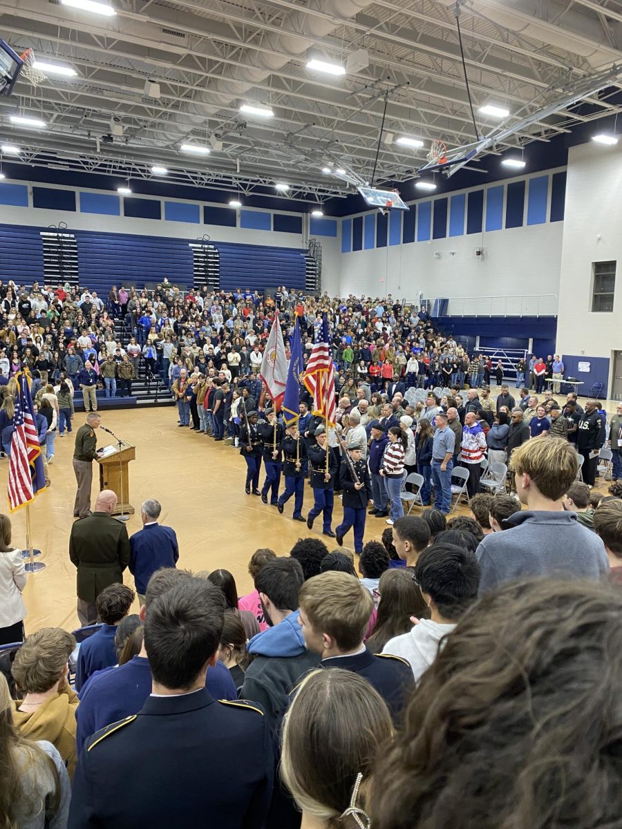 Students and veterans stand as JROTC performs the presentation of the colors during the assembly on November 11