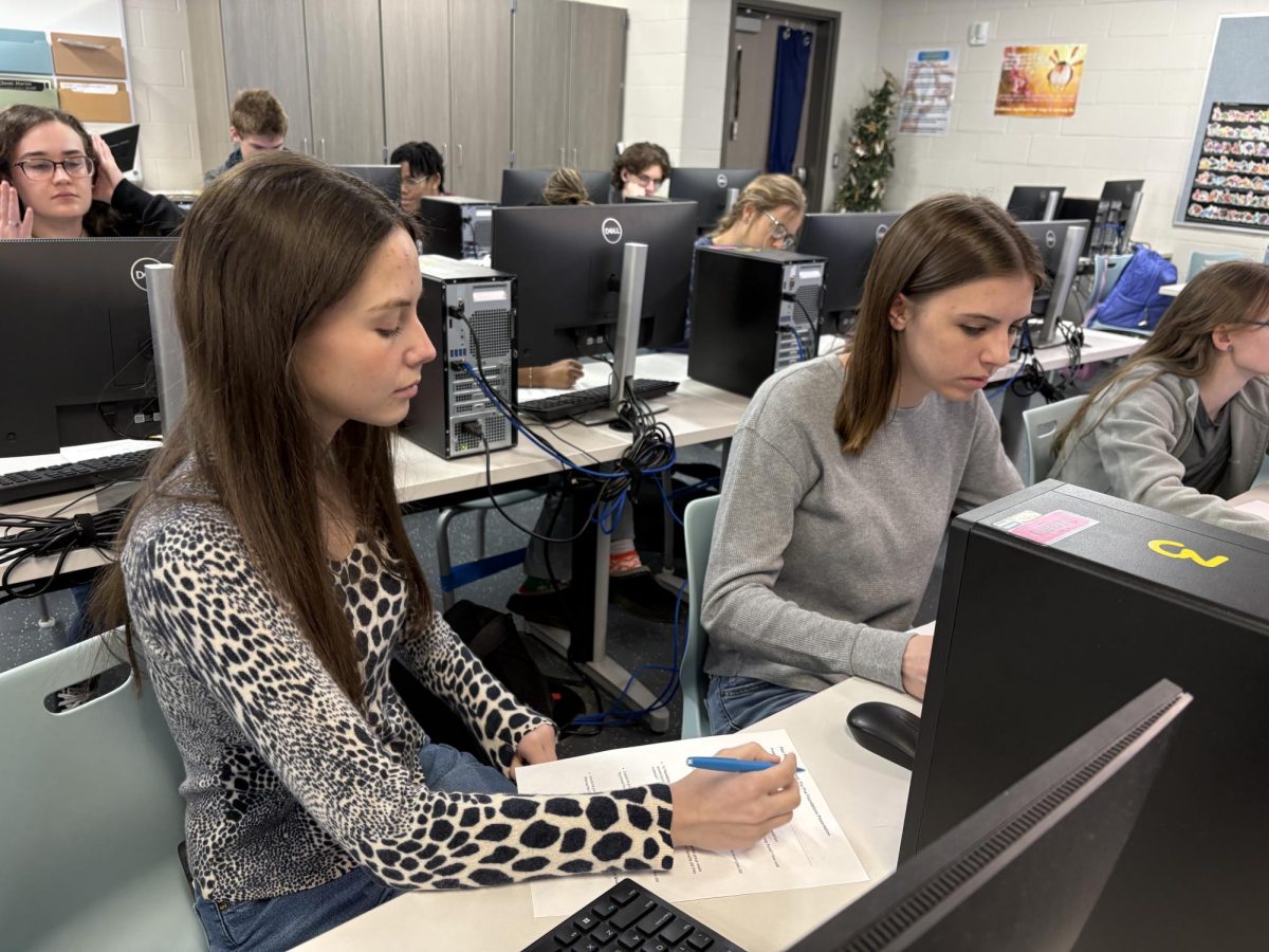 Seniors Addi Borders and Brianna Crouch use their "Effective Communicator" skills when reviewing each others projects in Melissa Trouts Business class on March 19th. 